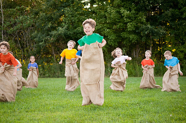 grupo de crianças felizes com batata corrida de saco de fora - child playing sack race sports race - fotografias e filmes do acervo