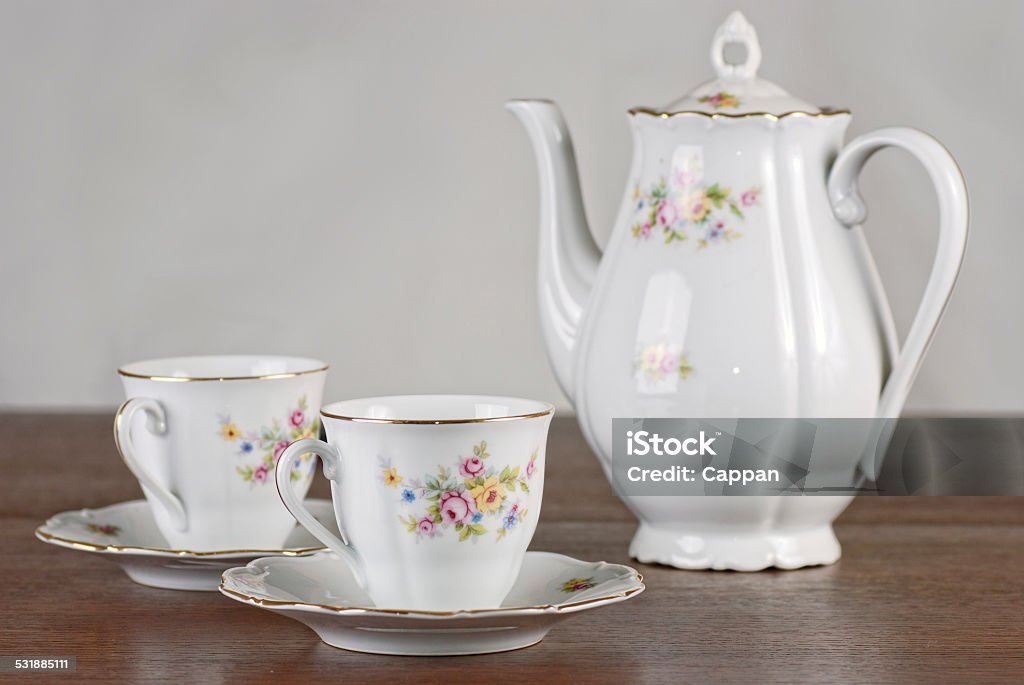 Classical porcelain tea set Classical porcelain tea set with floral motive on the wooden table Cup Stock Photo