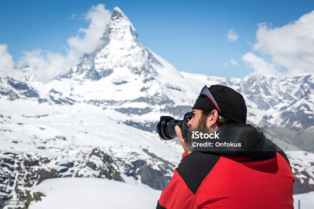 Man Photographer Taking Picture with DSLR Camera of Matterhorn, Switzerland Photographer at Zermatt, Switzerland 2015 Stock Photo