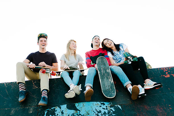 Group of teenagers relaxing & enjoying time together at the skate park.