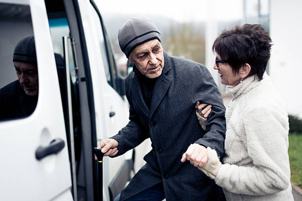istock nurse helping senior man enter a van 531888891
