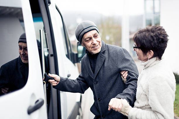 nurse helping senior man enter a van