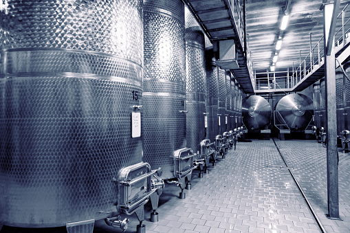 Stainless steel fermenters used to make wine, toned image