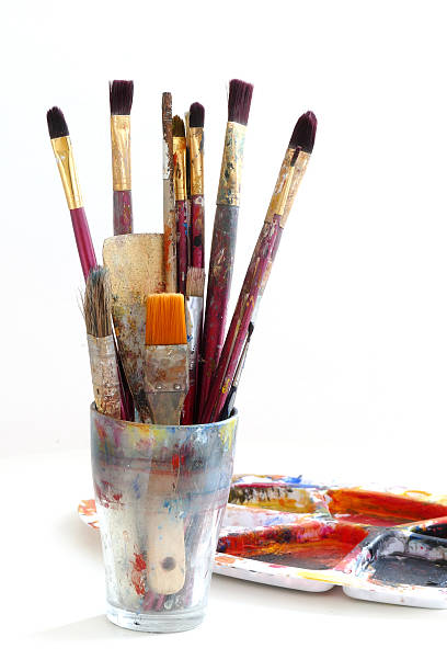 istock paint brushes in a glass and palette with colors, isolated 531901215