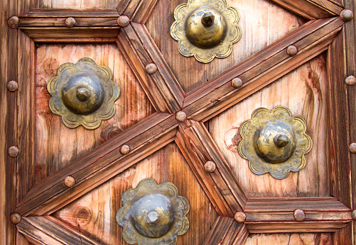 A detail from an ornate 19th-century wooden Indian door with bronze rosettes.