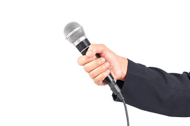 istock Business man holding a microphone isolated on white background 531904905