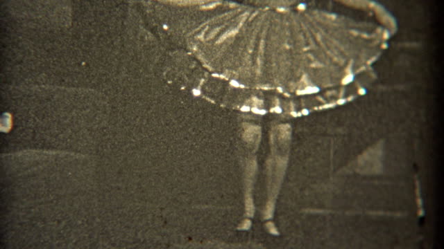 1936: Dancer practicing her craft indoors with fancy dress.