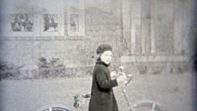 1937: Rich girl riding bike past mansions.