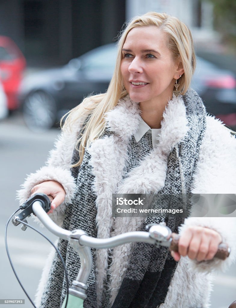 woman with bicycle blond woman on a bicycle and smiling 2015 Stock Photo
