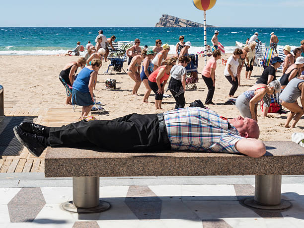 Benidorm Spain - February 5 - 2025 five unknown people sunbathing and greeting each other at the poniente beach in benidorm town in spain