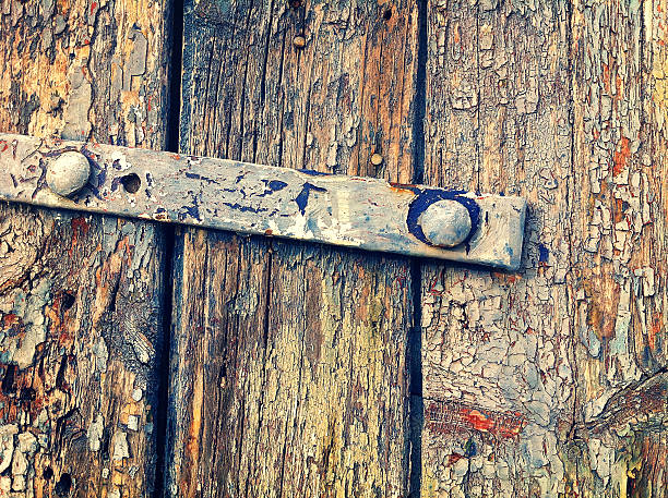 istock Old wooden door with peeling paint and rusty iron hinge 531919994