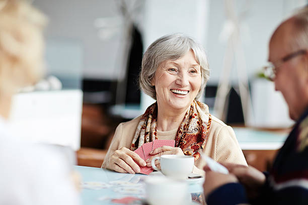 Positive granny with her friends Senior people playing cards in cafe senior lifestyle stock pictures, royalty-free photos & images