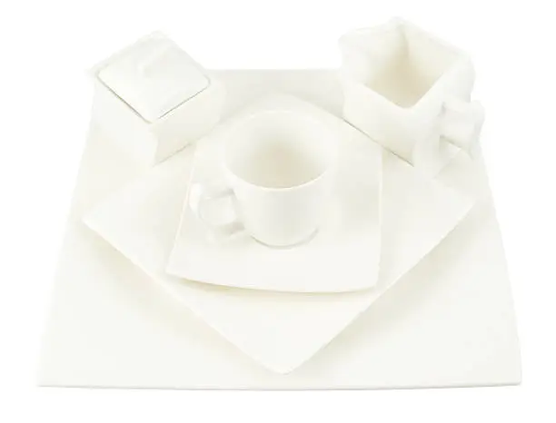 White ceramic sugar-bowl, cup and square plate composition isolated over white background