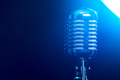 Metallic microphone isolated on a blue background.
