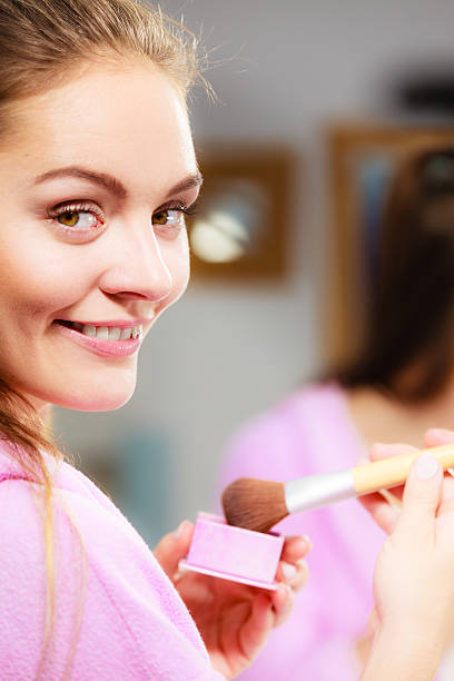 mulher aplicando maquiagem escova de bronzeamento com a sua pele - make up cosmetics make up brush beauty - fotografias e filmes do acervo