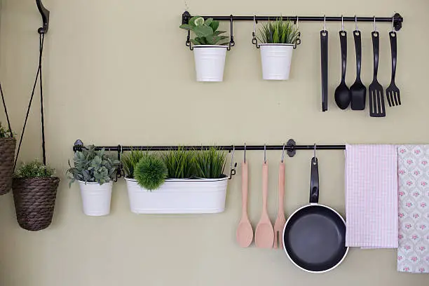Kitchenware and tree  hanging on the wall.