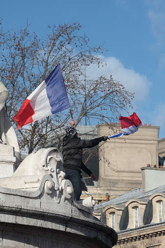 Paris, France - January 11, 2015: Black and arab people waving french flag during manifestation on Republic Square in Paris against terrorism and in memory of the attack against satirical newspaper Charlie Hebdo.