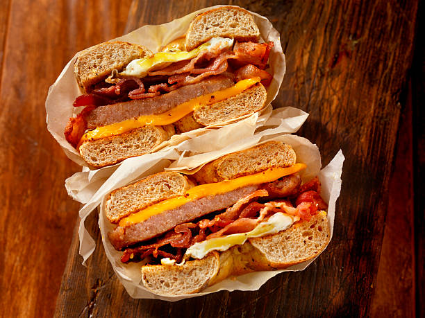 bajgiel, bekon, kiełbasa i jaj kanapka śniadaniowa - sandwich eggs bacon breakfast zdjęcia i obrazy z banku zdjęć