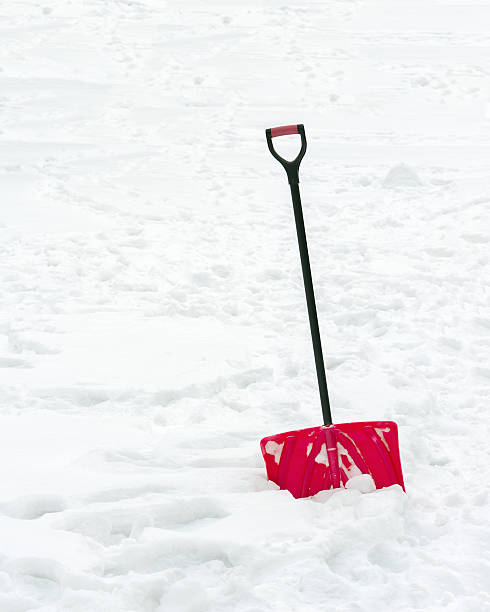 istock Red plastic shovel with black handle stuck in fluffy snow. 531931017