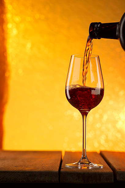 istock Pouring red wine from an elegant bottle into stylish wineglass 531931333