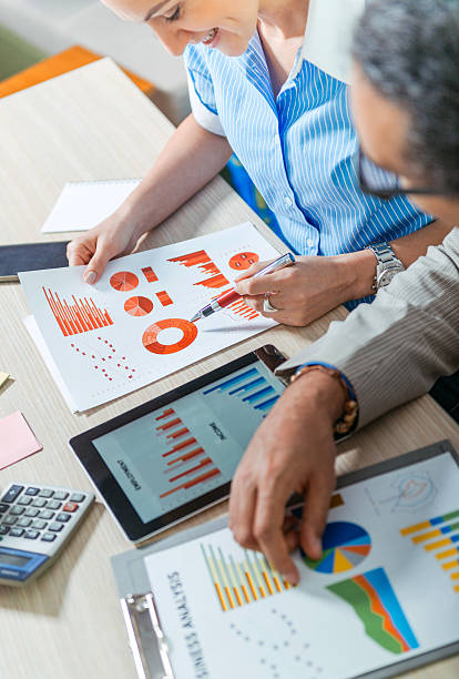 Successful young entrepreneurs analyzing stock market data in office