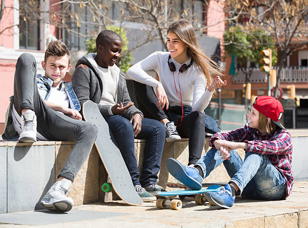 istock girl and three boys hanging out outdoors and discussing somethin 531934954
