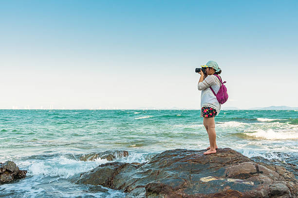 istock Woman is taking photograph at rock baech. 531935340