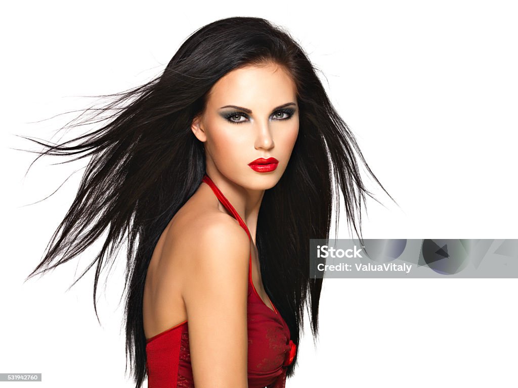 Portrait of  the beautiful woman with  black hairs and red Portrait of  the beautiful woman with  black straight hairs and red lips, evening makeup. Pretty model posing at studio Black Hair Stock Photo