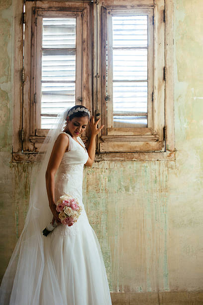 istock Beautiful Hispanic bride standing next to a window 531942836