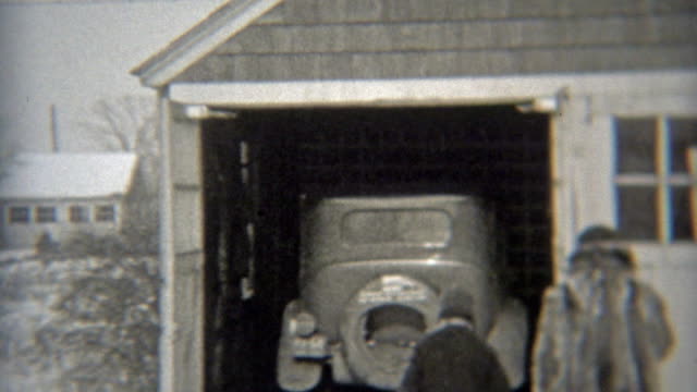 1938: During winter, family getting car from garage and backing up.