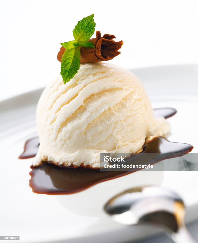 Ice cream and hot chocolate sauce Serving of ice cream and hot chocolate sauce garnished with shaved chocolate and mint 2015 Stock Photo