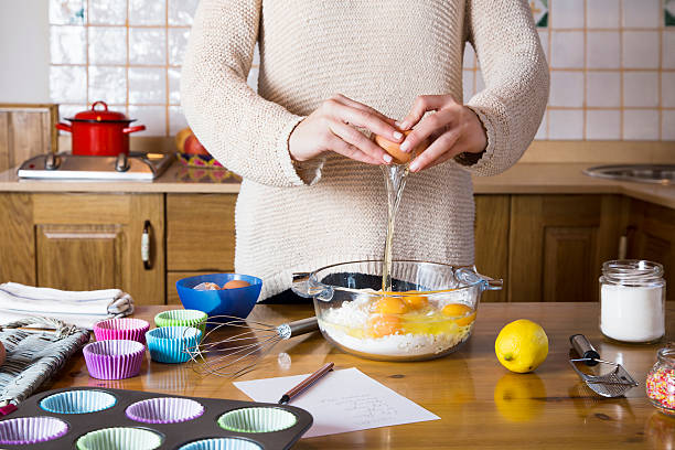 istock Woman hands breaking an egg to make cupcakes 531950637