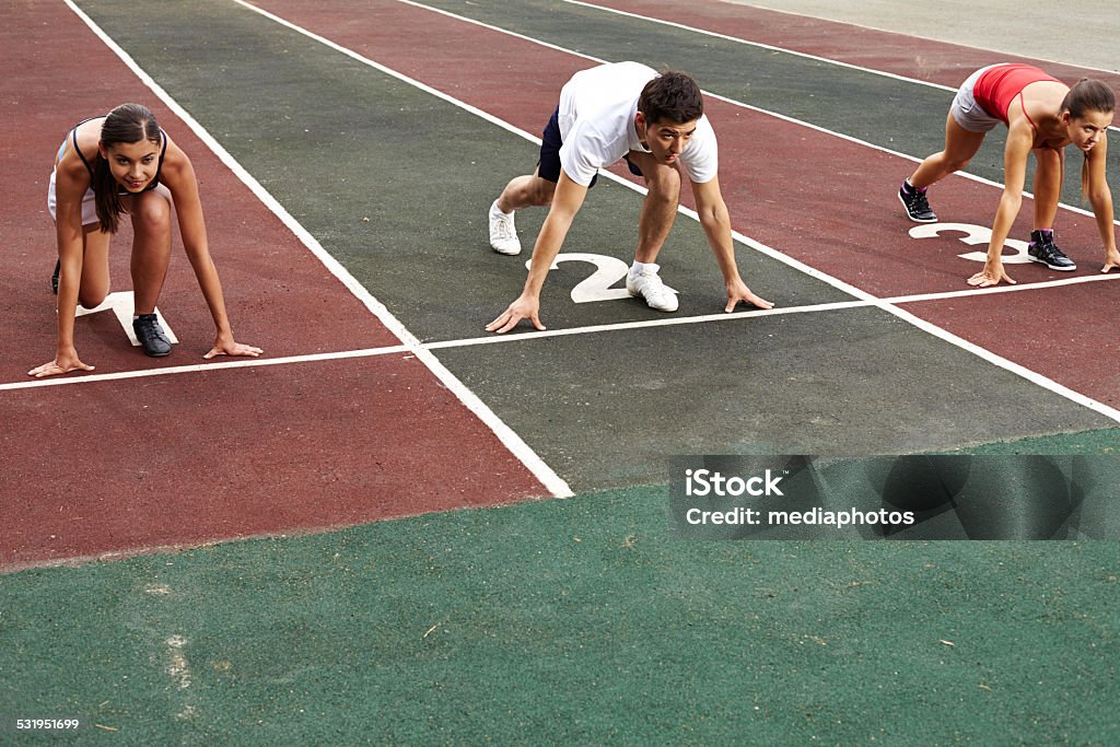 Ready, set, go! Three runners getting ready to start Asian and Indian Ethnicities Stock Photo