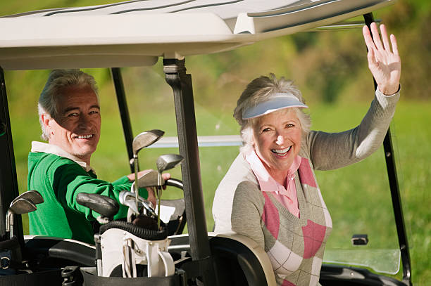 italie, kastelruth, couple d'âge mûr dans une voiturette de golf - golf cart golf bag horizontal outdoors photos et images de collection