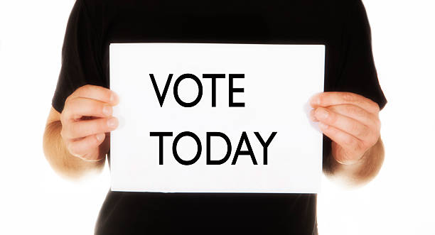 istock man holding white message bord with text  vote today 531953203