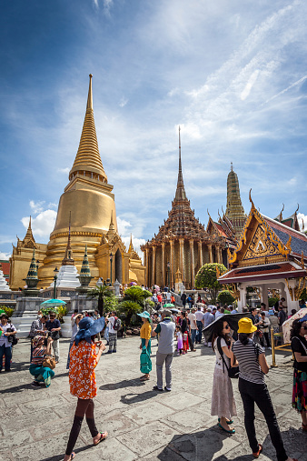 Bangkok, Thailand - April 26, 2013: Many tourists walking and taking pictures and enjoying the unique views of the famous Grand Palace temple in Bangkok.