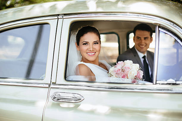 istock Hispanic bride and groom looking out of a classic car 531966644