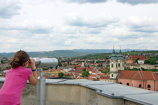 istock little girl looking through sightseeing binoculars on old town 531967016