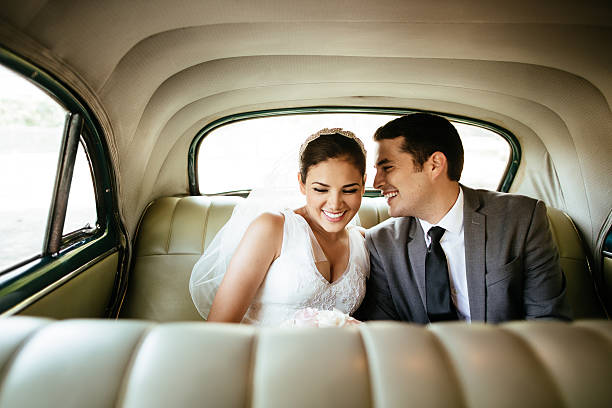 beautiful hispanic newlyweds laughing in backseat - nygift bildbanksfoton och bilder