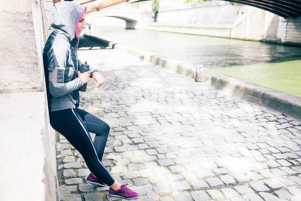 mujer joven controlar el pulso después de trotar - checking for rain fotografías e imágenes de stock