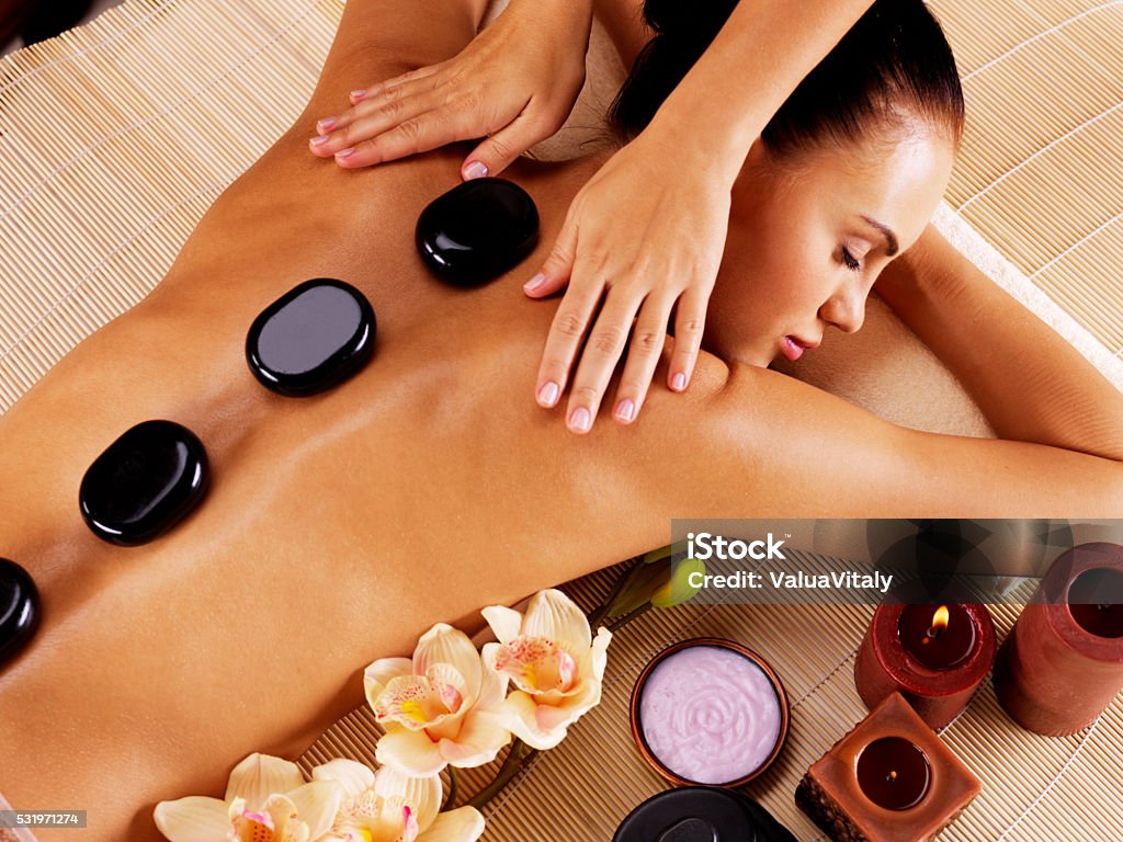 Adult woman having hot stone massage in spa salon Adult woman having hot stone massage in spa salon. Beauty treatment concept. Lastone Therapy Stock Photo
