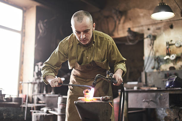 istock Blacksmith heats metal with a gas burner 531973438