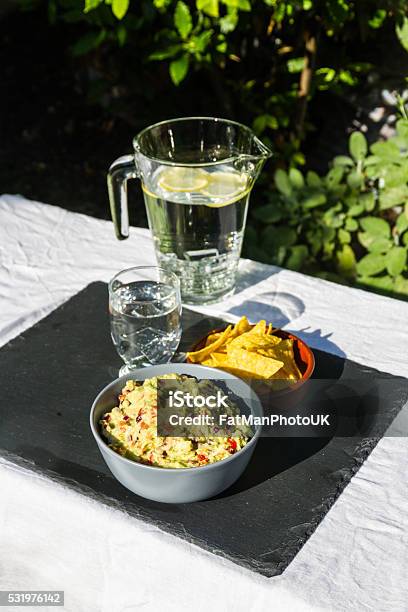 Guacamole In Bowl With Tortilla Chips And Iced Water Outdoors Stock Photo - Download Image Now