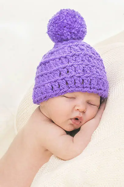 Photo of Cute newborn in knitted hat is sleeping