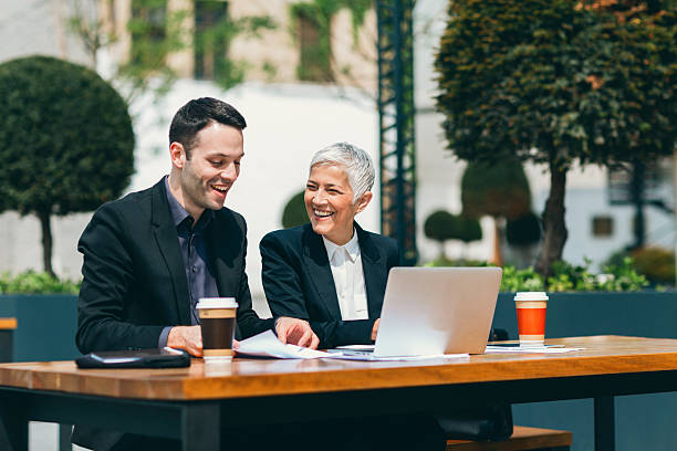 istock Businesspeople Sitting Outdoors In Tech Park And Using Laptop. 531980440