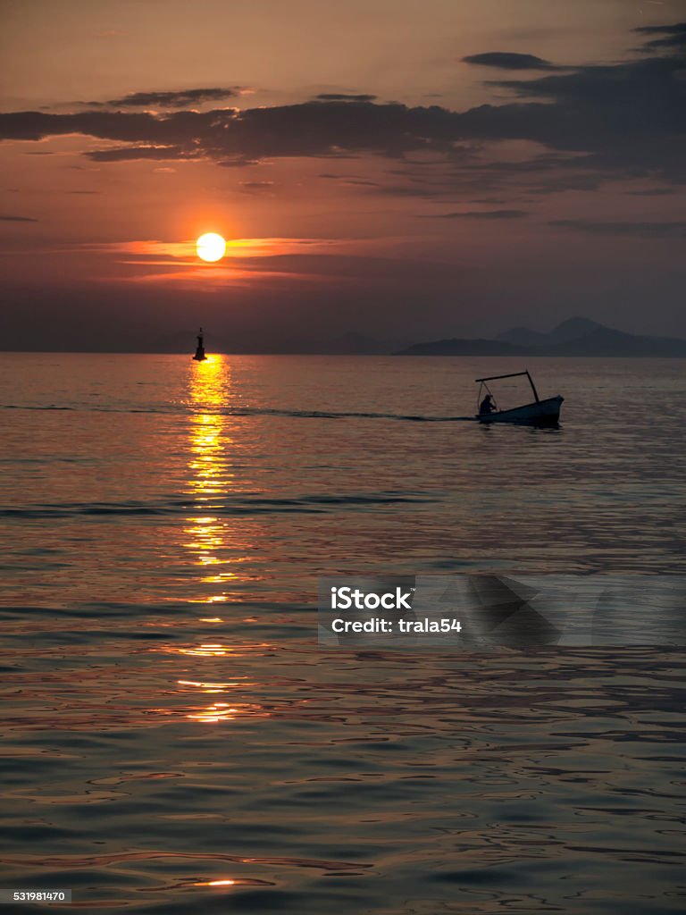 Silhouette of fisherman at the sunset Silhouette of Fisherman at sunset returns home Cavtat Stock Photo