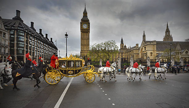 London pageantry London, UK -May 18th 2016:Queen Elizabeth II travels in a State golden carriage procession arrives at the Palace of Westminster to formally open the new session of Parliament  british royalty photos stock pictures, royalty-free photos & images
