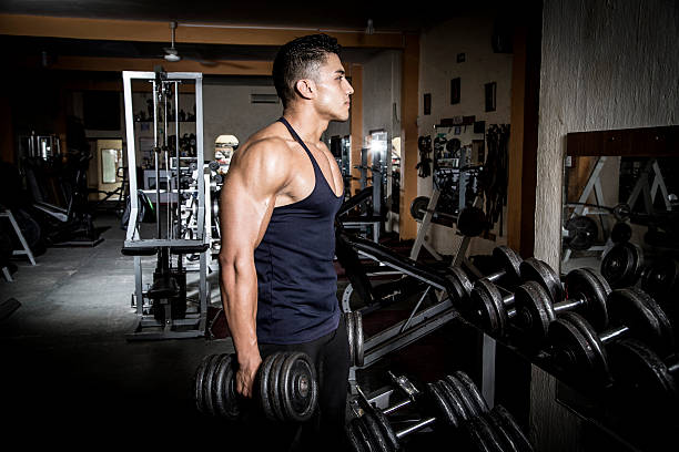 istock Young man exercising in dark and old gym 531982666
