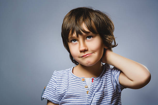 istock Closeup Thoughtful Young Boy Looking Up with Hand on Face 531982770