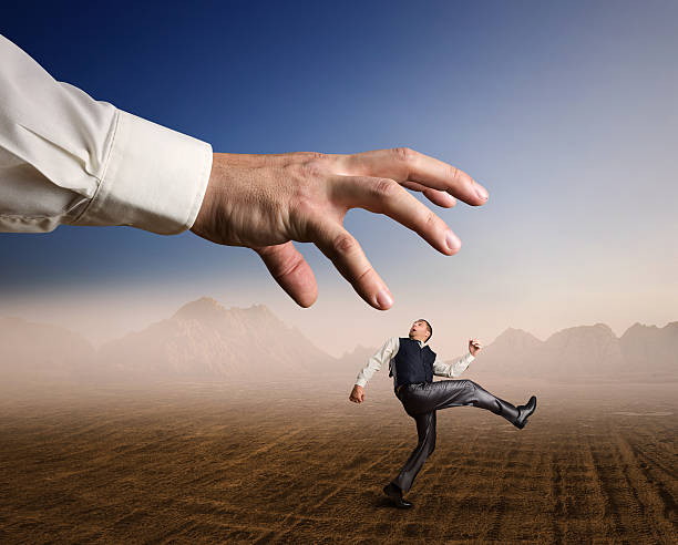 istock Businessman runs from a big arm 531984179